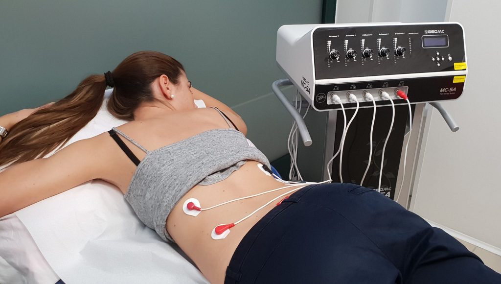 Donna sdraiata durante una seduta di Scrambler Therapy per la fibromialgia con elettrodi applicati sulla schiena